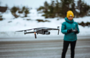 woman in blue jacket flying drone