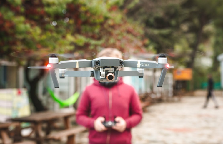 guy with a red jacket controlling drone